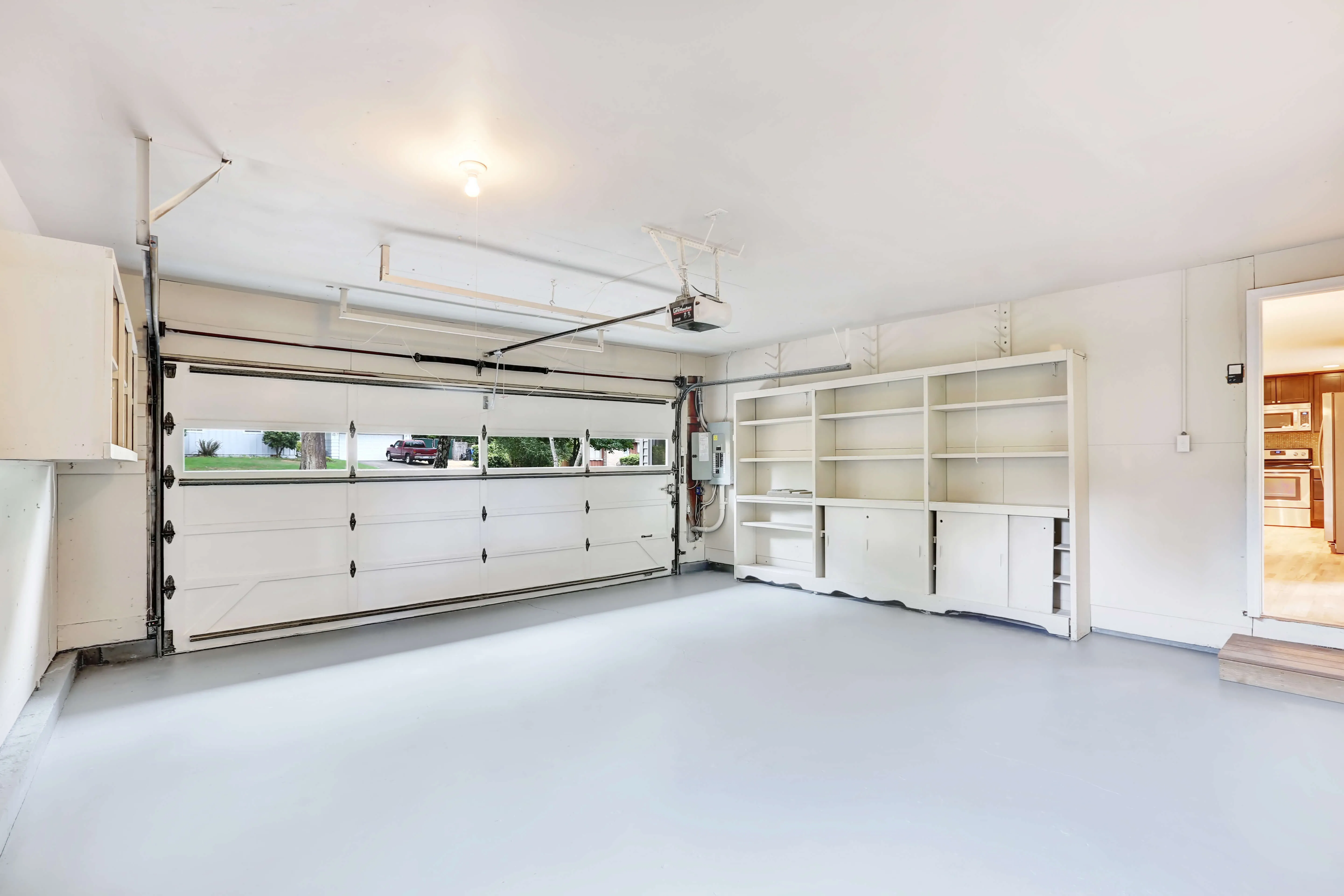 A room with a lot of white cabinets in it.